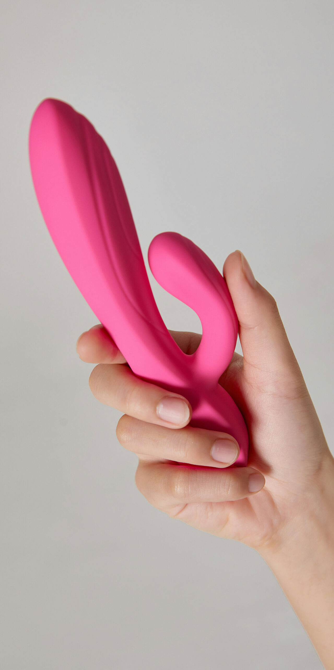 Girl's hand holding pink sex toy